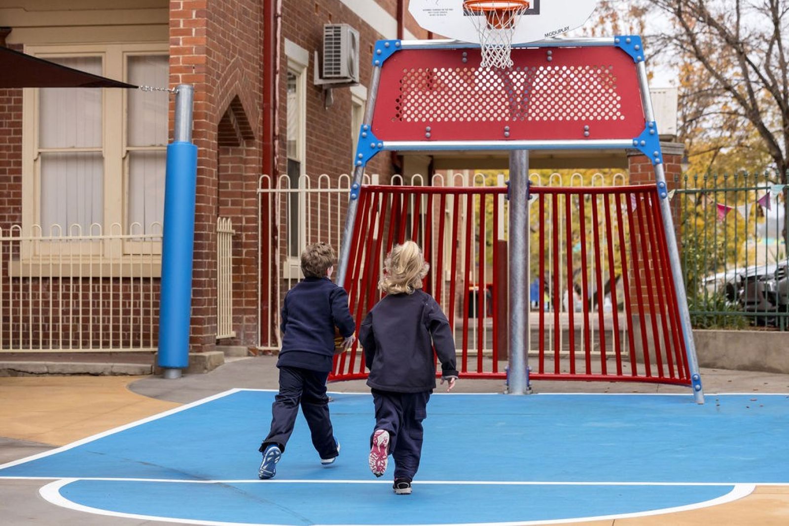 Students playing together on outdoor basketball court