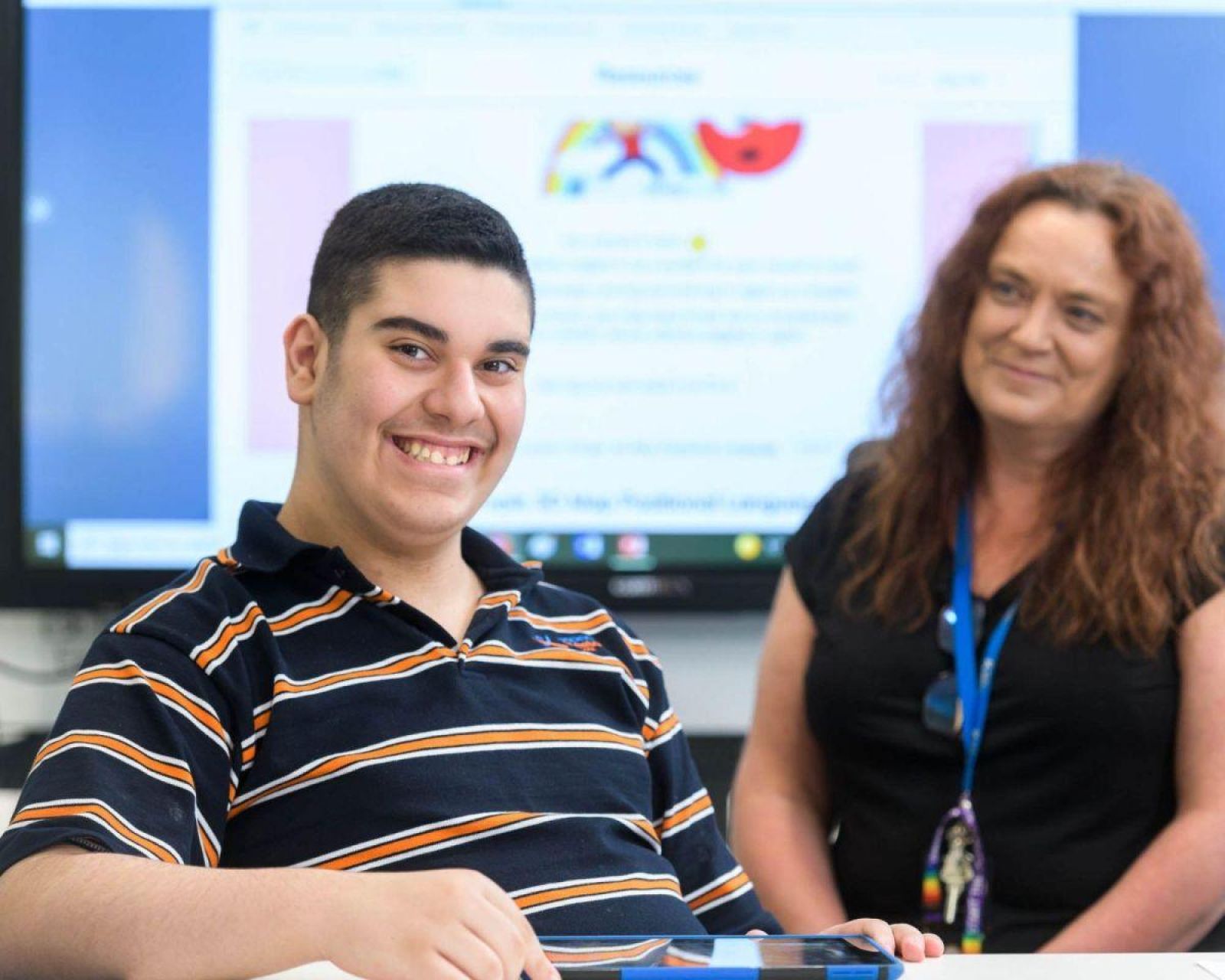 A teacher smiling at a happy student.