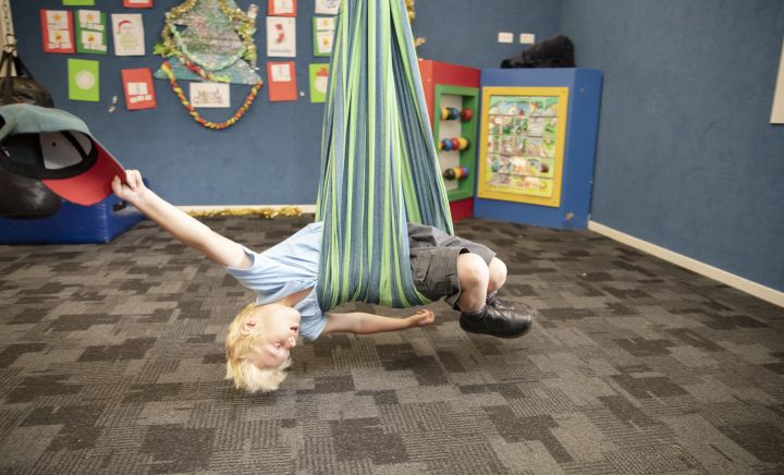 A student plays with a swing at Aspect Hunter School