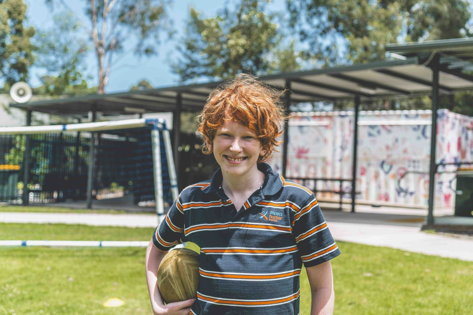 Student holding a rugby ball during outdoor play