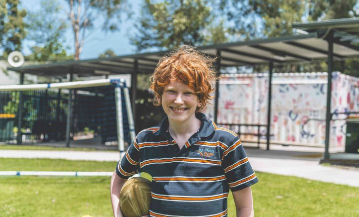 Student holding a rugby ball during outdoor play