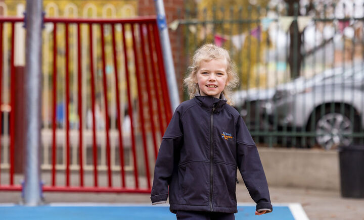 Young student smiling while walking across playground
